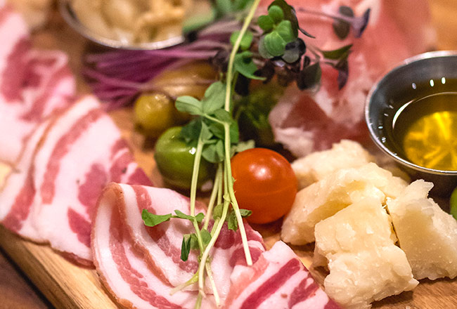 Charcuterie board with cheese, meets, olives and crispy bread